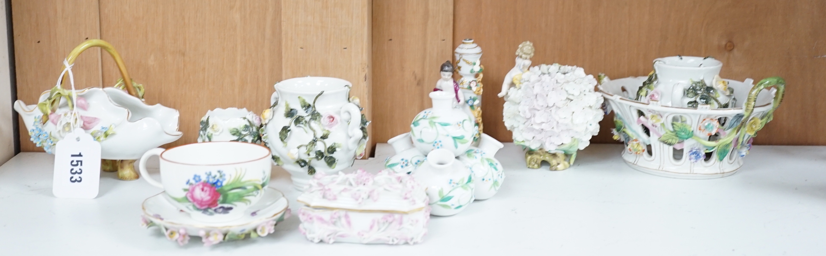 A group of German flower encrusted tableware, including a matched Meissen cup and saucer, lidded box, salts, figures, etc., tallest figure 12cm